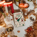 Retro Christmas cocktail party invitation displayed in a festive holiday table setting.