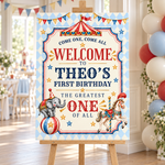 Vintage circus first birthday welcome sign on a wooden easel beside red, blue and ivory balloons.