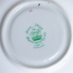 Close-up of a plate with 'Royal Crown Derby' branding on a white background