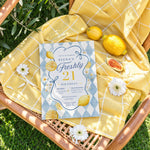 Freshly 21 lemon 21st birthday invitation styled on a sunny outdoor picnic blanket with flowers and citrus