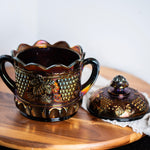 Decorative purple carnival glass jar with lid styled in moody vintage decor