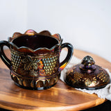 Decorative purple carnival glass jar with lid styled in moody vintage decor