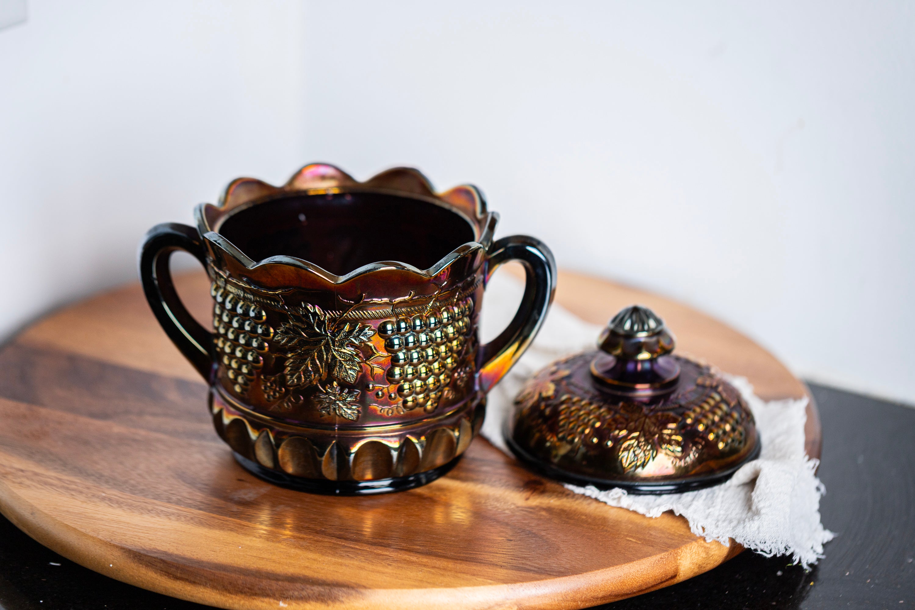 Decorative purple carnival glass jar with lid styled in moody vintage decor