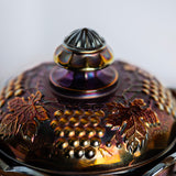 Antique electric amethyst carnival glass jar with ornate grape motif and lid