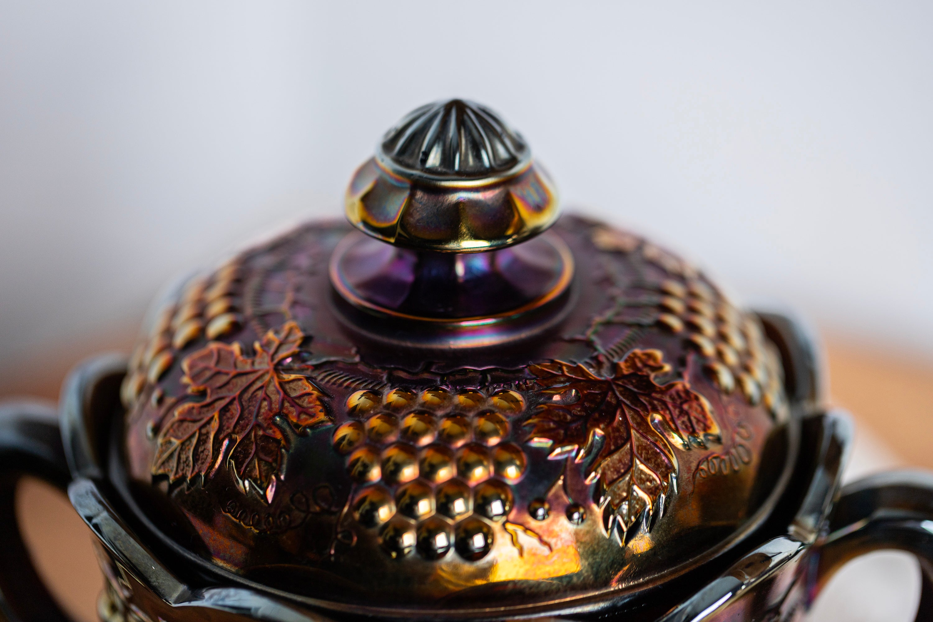 Antique electric amethyst carnival glass jar with ornate grape motif and lid