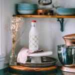Vintage Italian glass milk bottle 1970s on kitchen tray with apple and pear art deco design.
