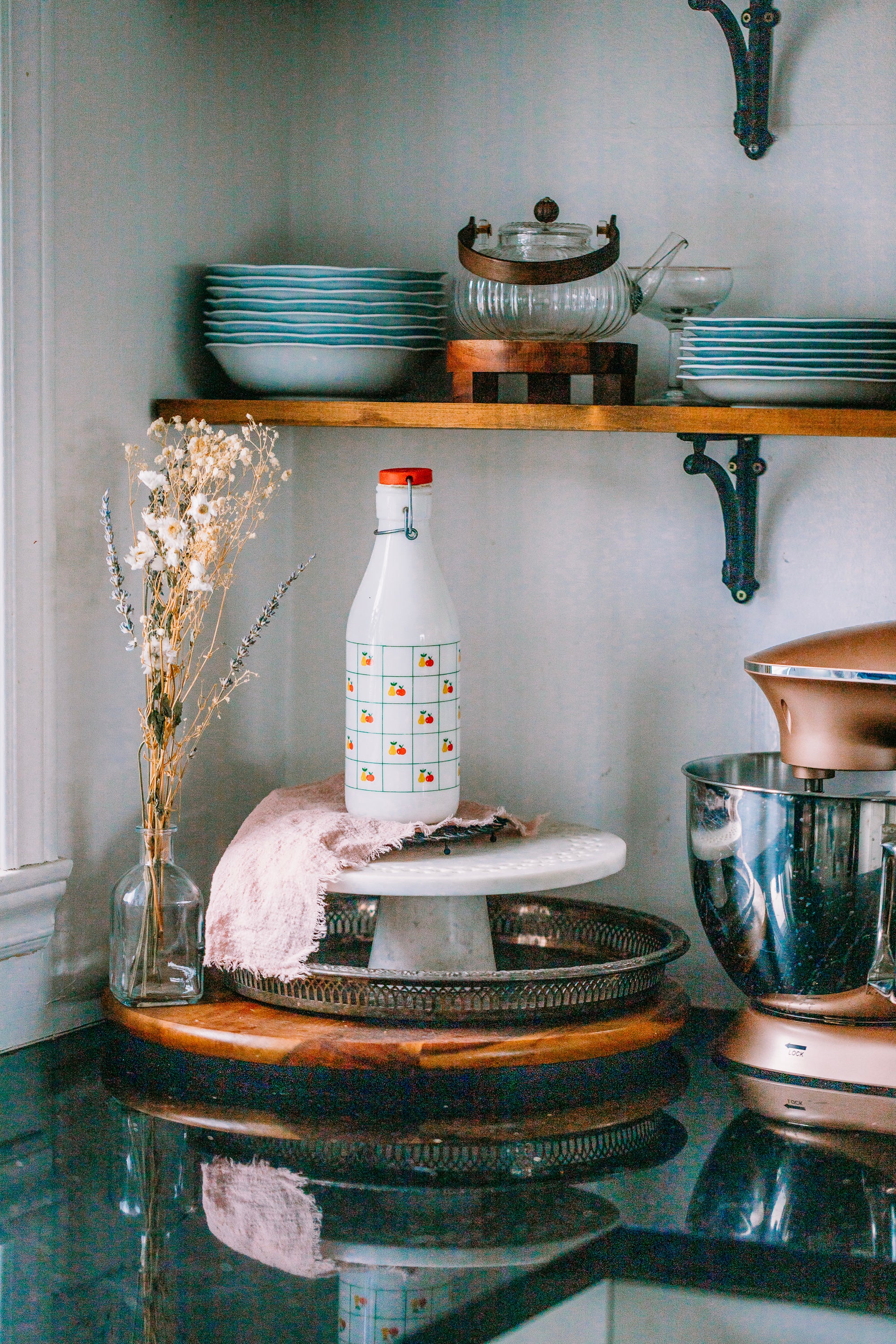 Vintage Italian glass milk bottle 1970s on kitchen tray with apple and pear art deco design.
