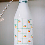 Art deco Italian milk bottle from 1970s, apple and pear design, styled on kitchen tray.