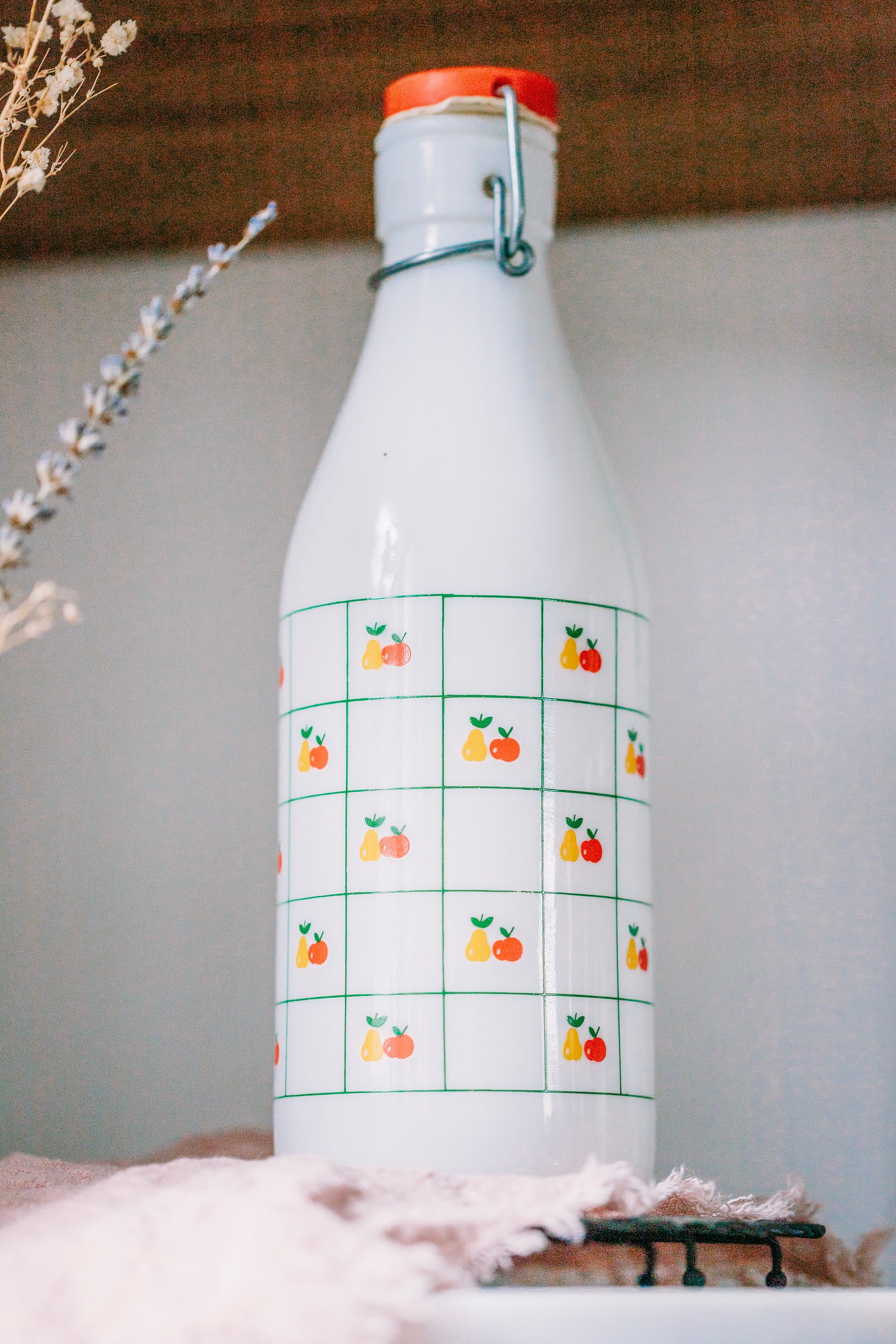 Art deco Italian milk bottle from 1970s, apple and pear design, styled on kitchen tray.
