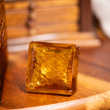 Square amber-colored glass block on a wooden surface