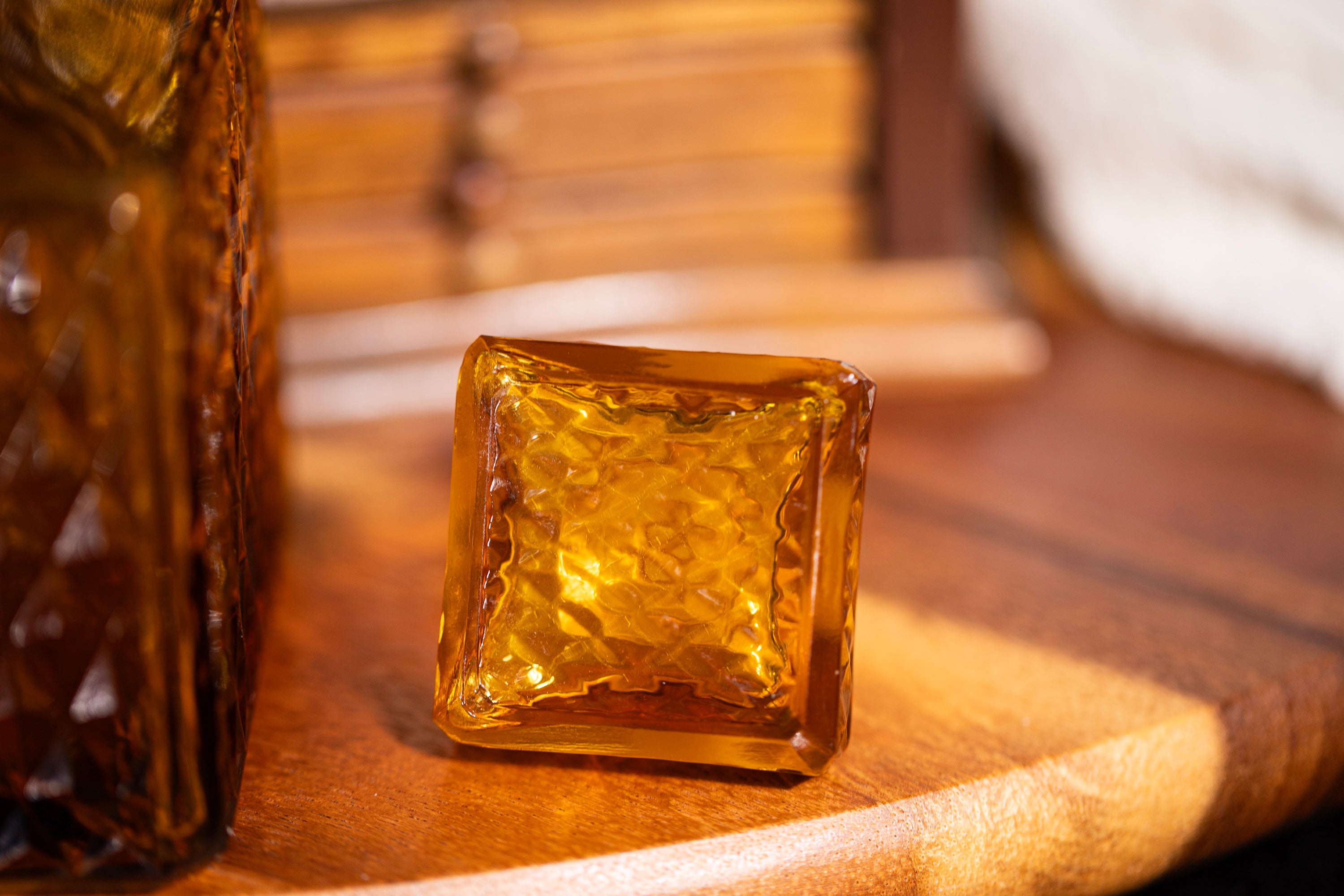 Square amber-colored glass block on a wooden surface