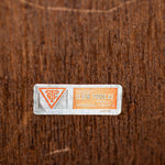 Small label with text and symbols on a textured brown background