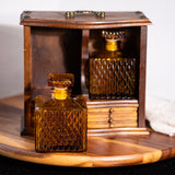 Two amber glass bottles with textured design inside a wooden display case on a wooden surface.