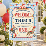 Circus birthday welcome sign on a white easel outdoors, surrounded by balloons, flowers and party bunting.