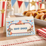 Folded vintage circus food label reading “Hot-Dogs” beside a platter of hot dogs and red striped napkins.