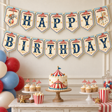 Vintage circus Happy Birthday banner with blue and gold letters, elephant and carousel horse pennants above a cake table.