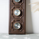 Wooden wall-mounted thermometer with decorative design on a light background