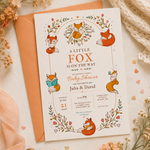 A Little Fox Is on the Way baby shower invitation with illustrated foxes and flowers, displayed on an orange envelope.